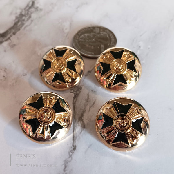 Four gold and black decorative buttons on a marble surface with a coin for scale.